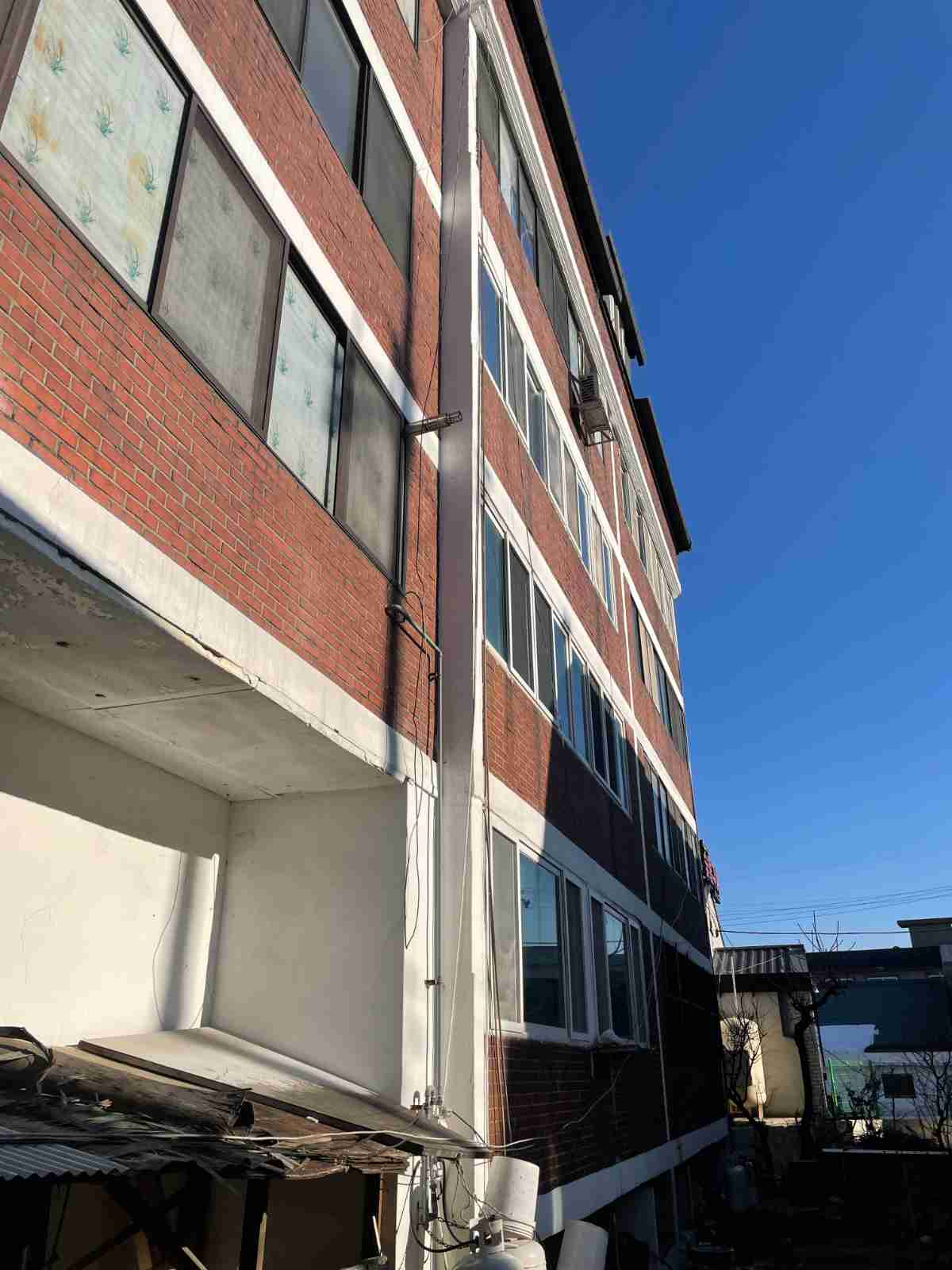 백암면 강림빌라 외벽 전경 - 적벽돌 외장 배관 관통부 누수 원인 조사